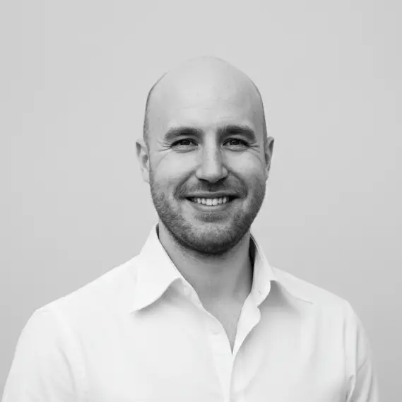 Portrait of Jesper Hartvig wearing a white shirt against a plain background.
