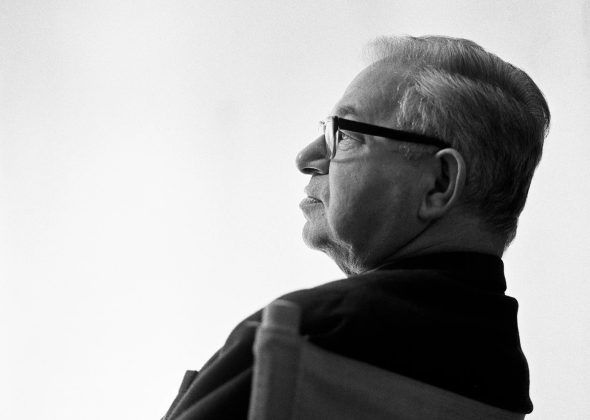 Sort-hvidt profilportræt af arkitekt Arne Jacobsen med briller og pibe.